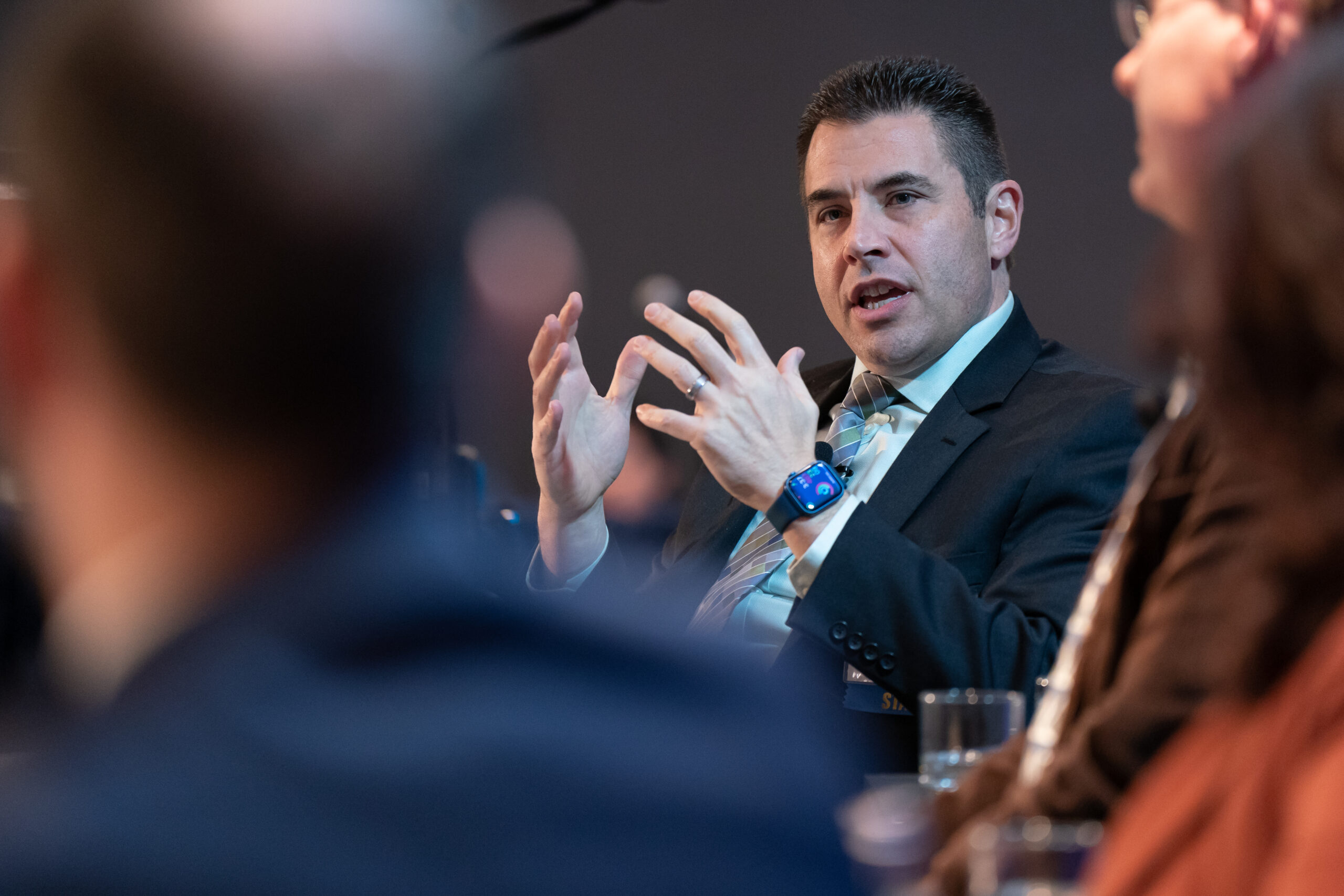 close-up of a man speaking on a discussion panel at a conference